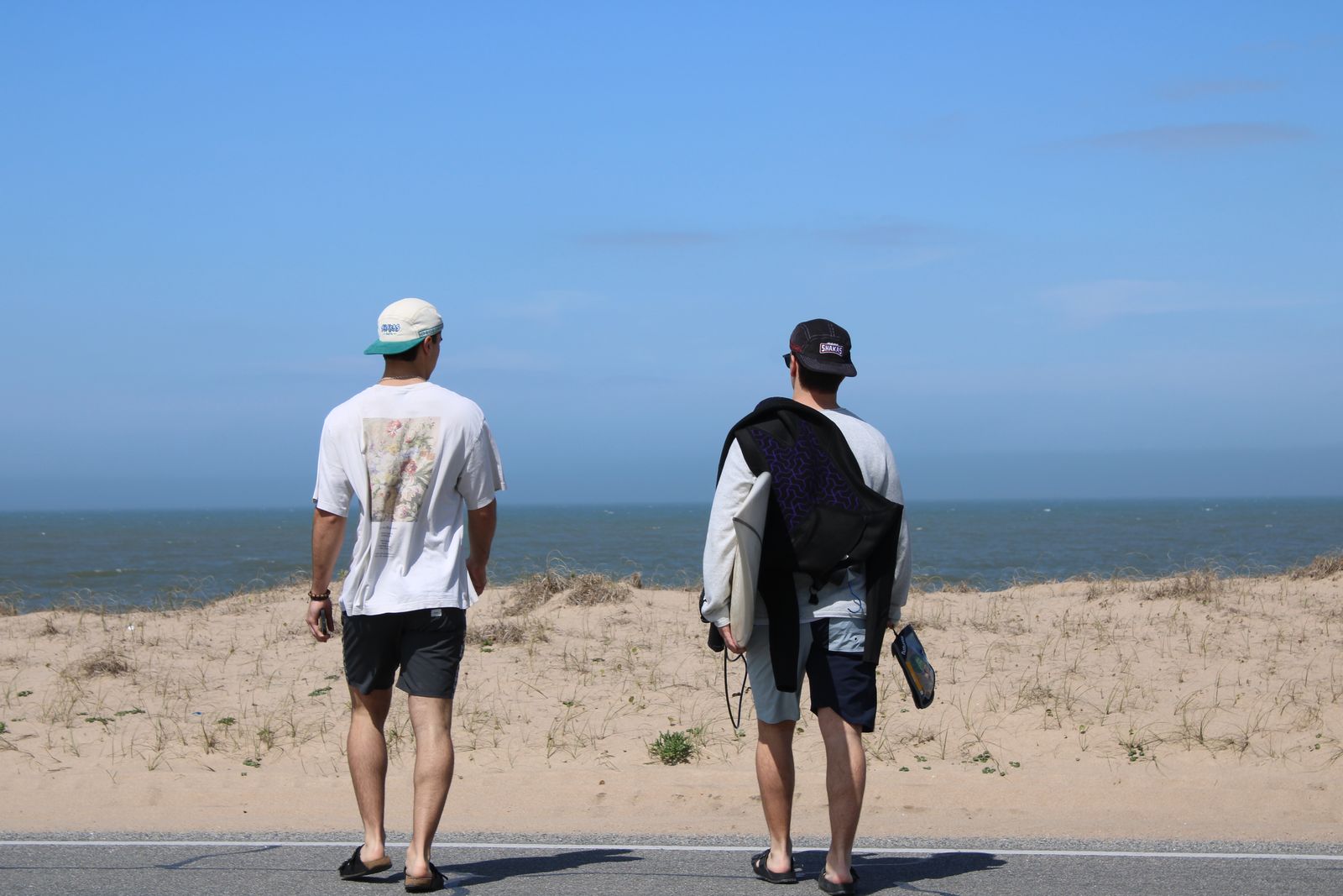Dos amigos con gorros Shakas caminando hacia el mar